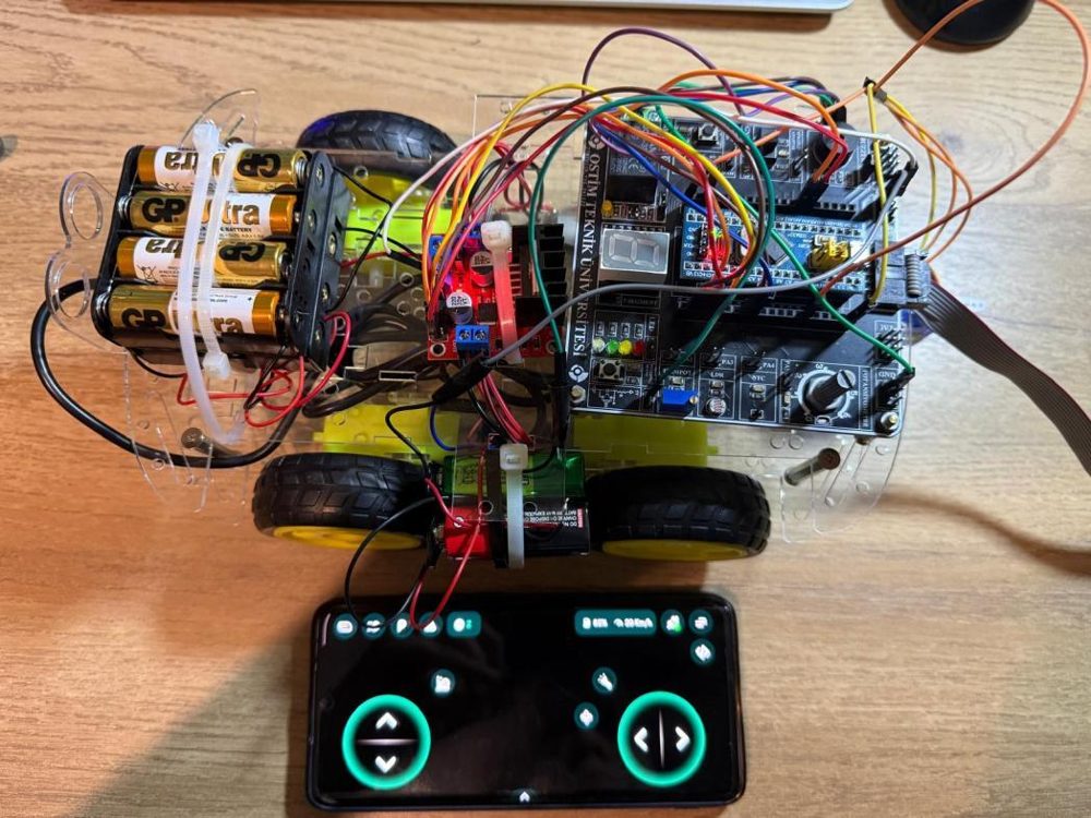 Top view of the robot: battery pack, motor driver, wired STM32 development board and the phone control interface